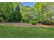 Lush green lawn with mature landscaping and trees in the backyard at 2265 Pemberton Pt, Buford, GA 30519