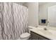 Neutral bathroom featuring a vanity with gray cabinet, toilet and shower with decorative curtain at 2265 Pemberton Pt, Buford, GA 30519