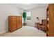 Cozy bedroom with a window, chair, wood armoire and shelving with light carpet at 2265 Pemberton Pt, Buford, GA 30519
