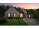 Charming home featuring a manicured lawn, red shutters, and a brick accent wall at sunset at 2265 Pemberton Pt, Buford, GA 30519
