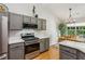 Modern kitchen featuring gray cabinets, stainless steel appliances, and hardwood floors at 2265 Pemberton Pt, Buford, GA 30519