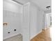 Bright laundry area with wood floors, laundry closet, and access to other rooms at 2329 Wavetree Nw Ln, Acworth, GA 30101