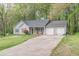 Traditional home featuring a two-car garage and neat lawn. Mature trees surround the house at 3805 Forsythia Way, Douglasville, GA 30135