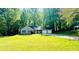 A single story home with a large grassy front yard and driveway, surrounded by mature trees at 3805 Forsythia Way, Douglasville, GA 30135