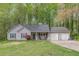 Traditional home featuring a two-car garage, neat lawn, and red chairs on the front porch at 3805 Forsythia Way, Douglasville, GA 30135