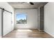 Bedroom with a barn door, modern ceiling fan, and skyline views at 860 Peachtree Ne St # 2118, Atlanta, GA 30308