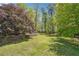 The level backyard with manicured lawn and mature trees at 255 Helens Manor Dr, Lawrenceville, GA 30045