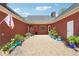 Private backyard patio surrounded by a brick exterior, colorful planters, and tasteful landscaping at 255 Helens Manor Dr, Lawrenceville, GA 30045