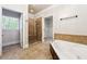 Bathroom with soaking tub, glass shower, access to walk-in closet, and a neutral color palette at 255 Helens Manor Dr, Lawrenceville, GA 30045