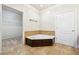 Bathroom with soaking tub, dark wood paneling, tile flooring, and access to walk-in closet at 255 Helens Manor Dr, Lawrenceville, GA 30045