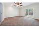 Light-filled bedroom with neutral carpet, ceiling fan, and sliding door access to the backyard at 255 Helens Manor Dr, Lawrenceville, GA 30045