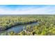 Aerial view of lush treed landscape, homes and neighborhood near a serene lake at 30 Sweetwood Ct, Roswell, GA 30076