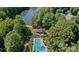Aerial view showcasing the community pool, clubhouse, and surrounding mature trees near the lake at 30 Sweetwood Ct, Roswell, GA 30076