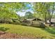 Backyard with lawn, trees, a fence, screened in patio, and a shed on a sunny day at 30 Sweetwood Ct, Roswell, GA 30076