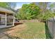 The backyard with a lawn, patio, wood fence, and a screened porch on the back of the house at 30 Sweetwood Ct, Roswell, GA 30076