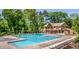 Community pool area with large pool, lounge chairs, clubhouse, and manicured landscaping at 30 Sweetwood Ct, Roswell, GA 30076