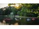 People enjoying the serene lake with kayaks and boats near the tree-lined shore with a house in the background at 30 Sweetwood Ct, Roswell, GA 30076