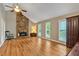 Bright and airy living room with hardwood floors, stone fireplace, and large windows at 30 Sweetwood Ct, Roswell, GA 30076