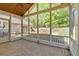 A screened porch featuring a fan and stone flooring overlooking the backyard at 30 Sweetwood Ct, Roswell, GA 30076