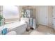 Bright bathroom featuring a soaking tub, tiled shower with glass door, and a neutral color palette at 4015 Two Bridge Ct, Buford, GA 30518
