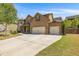 Two-story brick home with a three-car garage and a spacious driveway, set against a blue sky at 4015 Two Bridge Ct, Buford, GA 30518