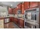 Gourmet kitchen featuring granite countertops, stainless steel appliances, and rich wood cabinetry at 4015 Two Bridge Ct, Buford, GA 30518