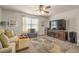 Cozy living room with plush seating, large TV, ceiling fan, and patterned rug over neutral carpet at 4015 Two Bridge Ct, Buford, GA 30518