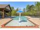 Community swimming pool featuring a mushroom fountain, shaded seating areas, and well-maintained surroundings at 4015 Two Bridge Ct, Buford, GA 30518