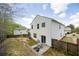 Backyard view featuring a patio with seating, a grassy area, wooden fence, and home's exterior at 6884 Barker Station Walk, Sugar Hill, GA 30518