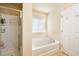 Bathroom with a shower, a soaking tub, and a window for natural light at 6884 Barker Station Walk, Sugar Hill, GA 30518
