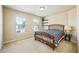 Cozy bedroom featuring carpet flooring, two windows offering plenty of natural light, and a wooden bed frame at 6884 Barker Station Walk, Sugar Hill, GA 30518