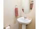 Charming half bathroom with a pedestal sink, decorative mirror, and neutral decor at 6884 Barker Station Walk, Sugar Hill, GA 30518