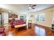 Spacious living room with hardwood floors, a ceiling fan, and an open view into the kitchen and dining area at 6884 Barker Station Walk, Sugar Hill, GA 30518