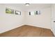 Finished basement room featuring wood-look flooring, two windows, neutral paint, and a door at 1690 Cotswold Ne Dr, Brookhaven, GA 30319