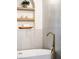 Bathroom features a large soaking tub with a gold faucet with decorative display shelves above the tub at 1690 Cotswold Ne Dr, Brookhaven, GA 30319