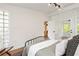 Bright bedroom featuring neutral colors, white trim, light wood floors, and a private screened-in porch at 1690 Cotswold Ne Dr, Brookhaven, GA 30319
