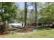 Exterior of home with mature trees, landscaping, stone walkway, and a lush green lawn at 1690 Cotswold Ne Dr, Brookhaven, GA 30319