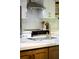 Close-up of kitchen sink with stainless steel faucet, stone countertops, and modern cabinetry at 1690 Cotswold Ne Dr, Brookhaven, GA 30319