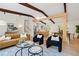 Bright living room with wood beam ceiling, modern furniture, and an open floor plan to the kitchen at 1690 Cotswold Ne Dr, Brookhaven, GA 30319