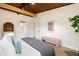 Comfortable main bedroom with dark wood-paneled ceiling, hardwood floors, and a view of the ensuite bathroom at 1690 Cotswold Ne Dr, Brookhaven, GA 30319