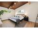 Serene main bedroom with dark wood-paneled ceiling, hardwood floors, and modern decor at 1690 Cotswold Ne Dr, Brookhaven, GA 30319