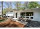 Outdoor patio features stylish seating, stone pavers, and a view of the landscaped yard at 1690 Cotswold Ne Dr, Brookhaven, GA 30319