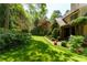 Expansive backyard featuring lush green lawn, mature trees, and a covered patio at 2167 W Wesley Nw Rd, Atlanta, GA 30327