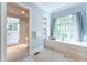 Bathroom with shower and adjacent window seat with storage and white cabinets with marble countertops at 2167 W Wesley Nw Rd, Atlanta, GA 30327