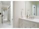 White-tiled bathroom featuring a sink vanity, an elegant mirror, and a glass door shower at 2167 W Wesley Nw Rd, Atlanta, GA 30327