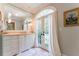 Bathroom vanity with white cabinets, marble countertop, large mirror, and french doors to the outside at 2167 W Wesley Nw Rd, Atlanta, GA 30327