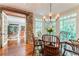 Bright dining area with stone wall, round wood table with chandelier, large windows and hardwood floors at 2167 W Wesley Nw Rd, Atlanta, GA 30327