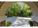 Arched stonework frames the paved driveway, offering a glimpse of the serene, wooded surroundings at 2167 W Wesley Nw Rd, Atlanta, GA 30327
