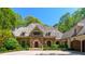 Stately stone home with shingle roof, manicured landscaping, and circular driveway, perfect for gracious living at 2167 W Wesley Nw Rd, Atlanta, GA 30327