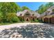 Gorgeous stone front exterior with arched entryway, large driveway, and mature trees at 2167 W Wesley Nw Rd, Atlanta, GA 30327